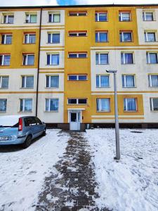 a yellow building with a car parked in front of it at Płonia Economy in Szczecin