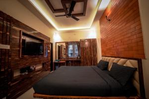 ein Schlafzimmer mit einem großen Bett mit Ziegelwand in der Unterkunft Melody Inn in Yercaud