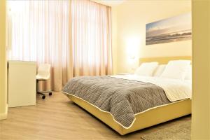 una camera con letto, scrivania e finestra di MIRAMAR Apart Hotel & SPA ad Aqtau