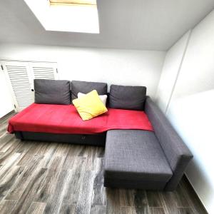 Sofá rojo con almohada amarilla en una habitación en Castle Harbour Duplex With Pool View C115 en Los Cristianos