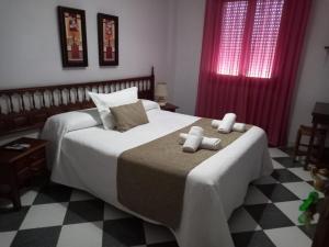 una camera da letto con un letto e due asciugamani di Hostal El Fogon De Felisa a Herrera del Duque