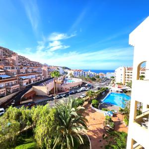 a view of a city and the ocean from a building at Castle Harbour Duplex With Pool View C115 in Los Cristianos