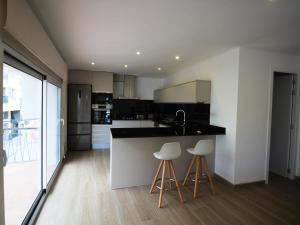 een keuken met een aanrecht en twee krukken. bij Apartamento Llançà, 3 dormitorios, 5 personas - ES-228-68 in Llança