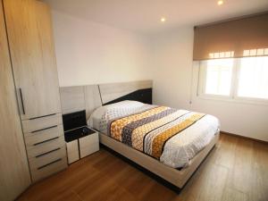een slaapkamer met een bed, een dressoir en een raam bij Apartamento Llançà, 3 dormitorios, 5 personas - ES-228-68 in Llança