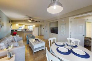 a kitchen and a living room with a table and chairs at 306 - Gulf Strand in St. Pete Beach +42 photos