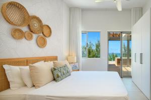 a bedroom with a large white bed with hats on the wall at Ocean Grand Gaube by 2futures Holidays in Grand Gaube