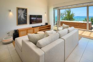 a living room with a couch and a television at Ocean Grand Gaube by 2futures Holidays in Grand Gaube
