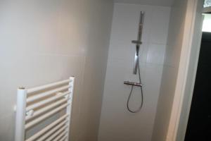 a bathroom with a shower with a hose on the wall at Zouterik 33* in Nieuwvliet +11 photos