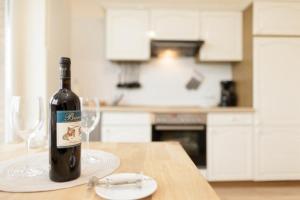 una botella de vino sentada en una mesa con dos copas en Marbijes Appartementhaus, en Cuxhaven