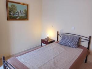 - une chambre avec un lit et une photo sur le mur dans l'établissement House in Amfilochia- Μονοκατοικία, à Amphilochie