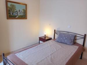 a bedroom with a bed and a picture on the wall at House in Amfilochia- Μονοκατοικία in Amfilochía
