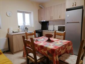 a kitchen with a table and a kitchen with a refrigerator at House in Amfilochia- Μονοκατοικία in Amfilochía +10 photos