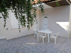 uma mesa branca e cadeiras num pátio em House in Amfilochia- Μονοκατοικία em Amfilochia