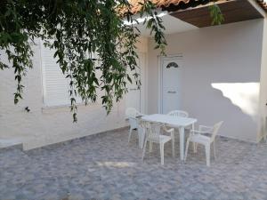 a white table and chairs on a patio at House in Amfilochia- Μονοκατοικία in Amfilochía