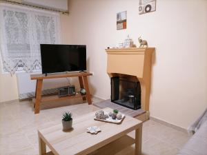 a living room with a fireplace and a flat screen tv at House in Amfilochia- Μονοκατοικία in Amfilochía
