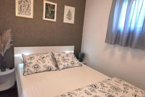 a bed with two pillows on it in a bedroom at Apartman Liburna in Rijeka