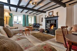a living room with a couch and a fireplace at Finest Retreats - No 2 Town Head Cottages in Grasmere