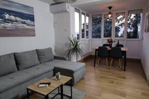 een woonkamer met een bank en een tafel bij Apartman Liburna in Rijeka