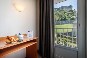 Zimmer mit einem Fenster und Blick auf ein Schloss in der Unterkunft Hôtel Compostelle in Lourdes