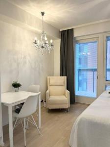 a bedroom with a bed and a table and a chair at City Island Studio Apartment, 4 beds, free street parking with parking disc, bus stop 200m in Helsinki