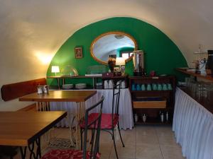 a room with two tables and a green wall at Guest House Olšakovský in Český Krumlov