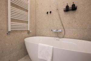 baño con bañera blanca y ventana en Brand-new 2-room apartment with a king size bed en Viena