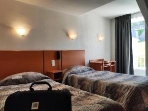 Postel nebo postele na pokoji v ubytování Hôtel Compostelle