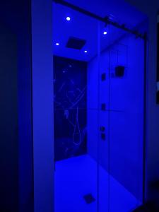 a dark room with a shower with blue lights at I Cappuccini Suite in Palermo