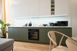 una cocina con armarios verdes y blancos y una silla en Brand-new 2-room apartment with a king size bed en Viena