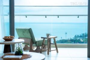 a room with a chair and a table and a window at The Song Vũng Tàu Luxury House in Vung Tau