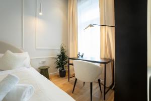 1 dormitorio con escritorio y silla junto a la cama en Brand-new 2-room apartment with a king size bed en Viena