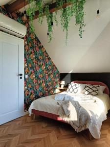 um quarto com uma cama e uma parede floral em Swobodna 6 Czapla Biała 