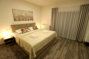 een slaapkamer met een bed met twee handdoeken erop bij Apartmani i sobe Laganini in Nova Gradiška