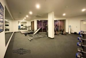 un gimnasio con cintas de correr y máquinas en una habitación en “CALLINGTON” Darwin City @PenthousePads en Darwin