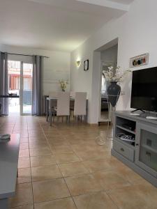 een woonkamer met een televisie en een tafel met stoelen bij Casa Greta in Costa de Antigua