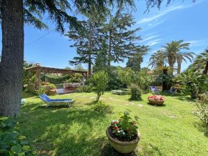 a yard with a bench and some plants and trees at Appartamenti Adriana di ArgonautiVacanze in Porto Azzurro