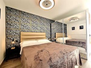 a bedroom with a large bed and a wall of wallpaper at Un pisito en Maspalomas in Maspalomas +22 photos