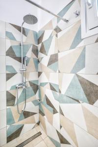 prysznic w łazience wyłożonej kafelkami geometrycznymi w obiekcie Catherine Blue Suites - 4 minutes off the Beach w mieście Poros