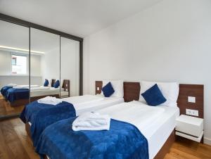 um quarto de hotel com duas camas e um espelho em Nook Zehn Apartments & Loft by Irundo em Viena