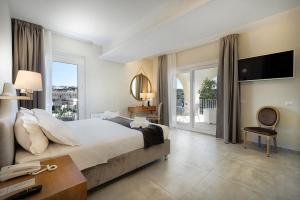 a bedroom with a large bed and a balcony at Itria Modica in Modica