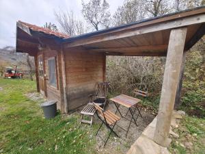 a cabin with two chairs and a table and a bench at Agriturismo Fattoria Ca Di Sole in San Benedetto Val di Sambro