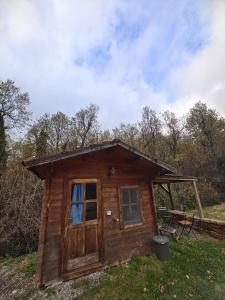 a small cabin with a door and a picnic table at Agriturismo Fattoria Ca Di Sole in San Benedetto Val di Sambro