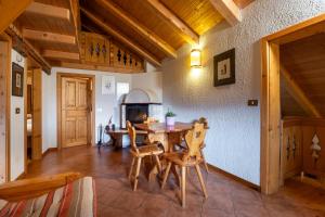 a dining room with a wooden table and chairs at Baita Vioz in Peio