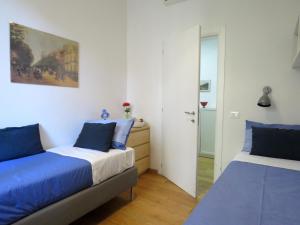 Santa Croce Apartments في بولونيا: غرفة نوم بسريرين ومرآة