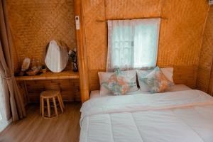 a small bedroom with a bed and a window at ชีวาวิลล์ ฟาร์มสเตย์ - Cheewavill farmstay in Ban Ko