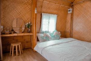 a bedroom with a bed and a window and a stool at ชีวาวิลล์ ฟาร์มสเตย์ - Cheewavill farmstay in Ban Ko