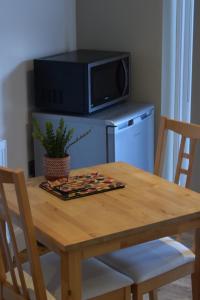 a wooden table with a microwave and a table with chairs at Cherry Farmhouse in York +18 photos