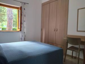 プラーイア・ア・マーレにあるVillaggio Turistico La Mantinera - Residenceのベッドルーム1室(ベッド1台、デスク、窓付)