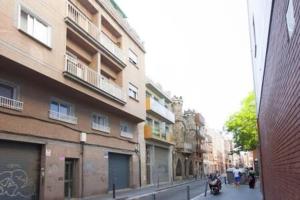 una calle con edificios y una persona en una moto en Designer Apt near FIRA Balcony 5PPWIFISMART TV by MyRentalHost, en Hospitalet de Llobregat