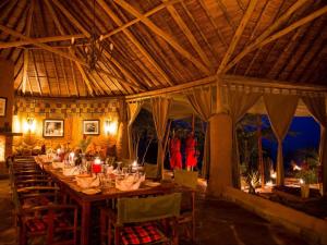 a large dining room with a long table with candles at Kilima Camp - Safari in Masai Mara in Lolgorien